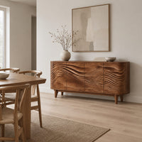 Sideboard with four wave carved doors and tapered legs in a Scandinavian dining room with white walls
