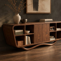 Corner detail of tapered sideboard with open cubbies on both sides and a wavy base beside wood, brass and linen samples