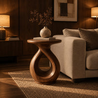 Round side table on a looped teardrop pedestal with a flat disc base in an evening living room with walnut wall paneling