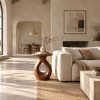 Round side table on a looped teardrop pedestal with a flat disc base in a bright open plan living room