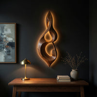 Twisted teardrop note wall sculpture in wood above a desk in a dark study corner