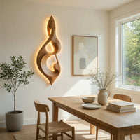 Twisted teardrop note wall sculpture in wood beside a dining table in natural light