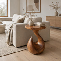 Circular side table on a teardrop pedestal with a swirling neck in a Scandinavian living room with white walls