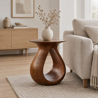 Teardrop side table with a flared top and an open loop body in a Scandinavian living room with white walls