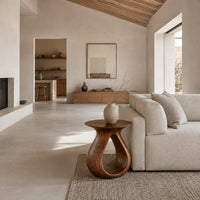 Teardrop side table with a flared top and an open loop body in a bright open plan living room