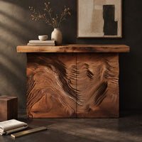 Corner detail of console table with deep ridged terrain carving across the front beside wood, brass and linen samples