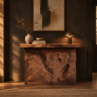 Console table with deep ridged terrain carving across the front in a dark entryway at golden hour