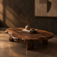 Low coffee table with a thick live edge slab top on short chunky legs, three-quarter view showing the grain