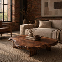 Low coffee table with a thick live edge slab top on short chunky legs in an industrial loft living room with exposed brick