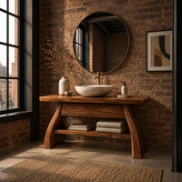 Freestanding vanity with a thick slab top, flared legs and a low shelf in an industrial loft bathroom with exposed brick