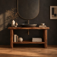 Bathroom vanity with a thick slab top, plank legs and a low shelf in a dark studio against a charcoal plaster wall
