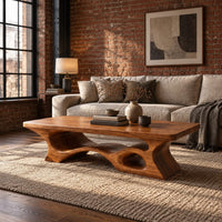Thick slab coffee table with a carved cutout base in an industrial loft living room with exposed brick