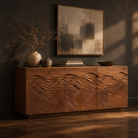 Low sideboard with three doors carved in flowing waves on a plinth base, three-quarter view showing the grain