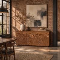Low sideboard with three doors carved in flowing waves on a plinth base in an industrial loft dining room with exposed brick