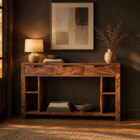 Console table with three drawers, open side cubbies and a lower shelf in a dark entryway at golden hour