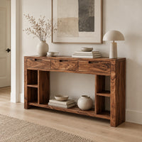 Console table with three drawers, open side cubbies and a lower shelf in a Scandinavian entryway with white walls