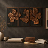 Detail of three panel carved floral relief wall art with large petals on dark panels beside wood, brass and linen samples