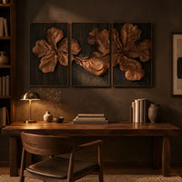 Three panel carved floral relief wall art with large petals on dark panels above a desk in a dark study corner