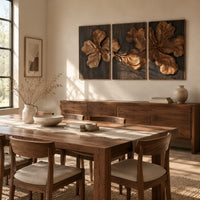 Three panel carved floral relief wall art with large petals on dark panels beside a dining table in natural light