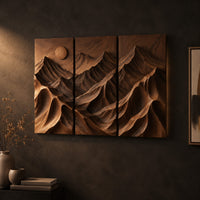 Three panel carved mountain relief wall art with a sun disc on a dark charcoal plaster wall
