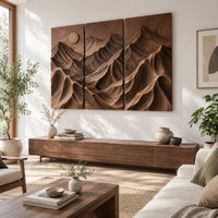 Three panel carved mountain relief wall art with a sun disc in a bright sunroom with green plants