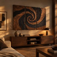 Three panel spiral wall art with a carved black swirl on warm wood above a low console in an evening living room