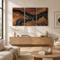 Three panel wood grain wall art with a dark flowing river band above a light oak sideboard in daylight