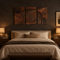 Three panel wall art with flowing carved grain pattern above a bed in a dusk lit bedroom
