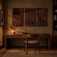Three panel wall art with flowing carved grain pattern above a desk in a dark study corner