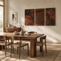 Three panel wall art with flowing carved grain pattern beside a dining table in natural light