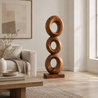 Stacked three ring sculpture with open centers on a flat plinth in a Scandinavian living room with white walls