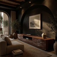 Media cabinet with wave carved doors around an open niche in a living room at golden hour