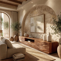 Media cabinet with wave carved doors around an open niche in a sunlit room with large windows and plants
