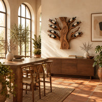 Carved tree shaped wine rack with a thick trunk and branches in a bright dining room with arched windows and plants
