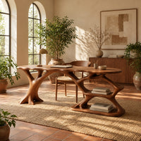 Desk with an oval top on a forked trunk leg and open branching shelves in a bright home office with arched windows and plants