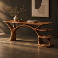 Wooden desk shaped like a tree with branching legs and two open shelves, three-quarter view showing the grain