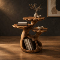 Tree shaped side table with three petal edged tops and a hollow trunk in a dark studio against a charcoal plaster wall