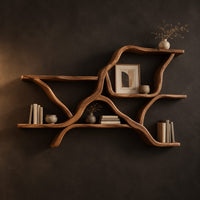 Wall shelves in a branching limb shape with uneven tiers in a dark studio against a charcoal plaster wall