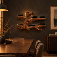 Tree root wine bottle holder with gnarled branching arms in a dark dining room at golden hour