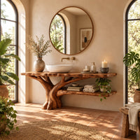 Tree trunk bathroom vanity with a branching base and a low side shelf in a bright bathroom with arched windows and plants