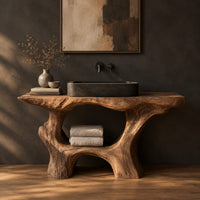 Tree trunk bathroom vanity with a natural edge top and open arched base in a dark studio against a charcoal plaster wall