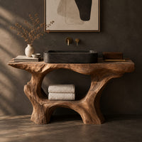Corner detail of tree trunk bathroom vanity with a natural edge top and open arched base beside wood, brass and linen samples