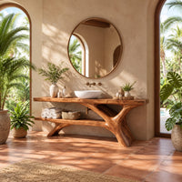 Tree trunk bathroom vanity with a slab top and an open lower shelf in a bright bathroom with arched windows and plants