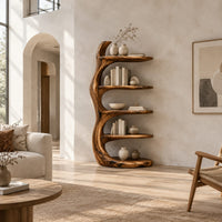 Tree trunk bookshelf with five tiered shelves branching from a twisting stem in a bright open plan living room