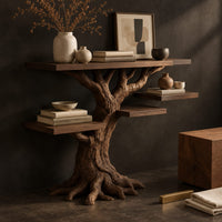 Corner detail of console table shaped like a tree with root feet and staggered shelves beside wood, brass and linen samples