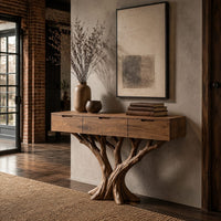 Console table with three drawers on a carved tree trunk base in an industrial loft entryway with exposed brick