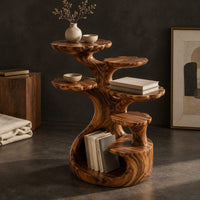 Corner detail of tree shaped end table with scalloped tiers and a curled base nook beside wood, brass and linen samples