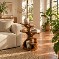 Tree shaped end table with scalloped tiers and a curled base nook in a bright living room with arched windows and plants