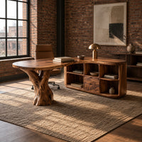 Desk with a carved tree trunk pedestal and a wing of open cubbies in an industrial loft home office with exposed brick