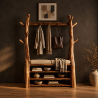 Tree trunk wardrobe with a top beam and bench seat above open shelves in a dark studio against a charcoal plaster wall